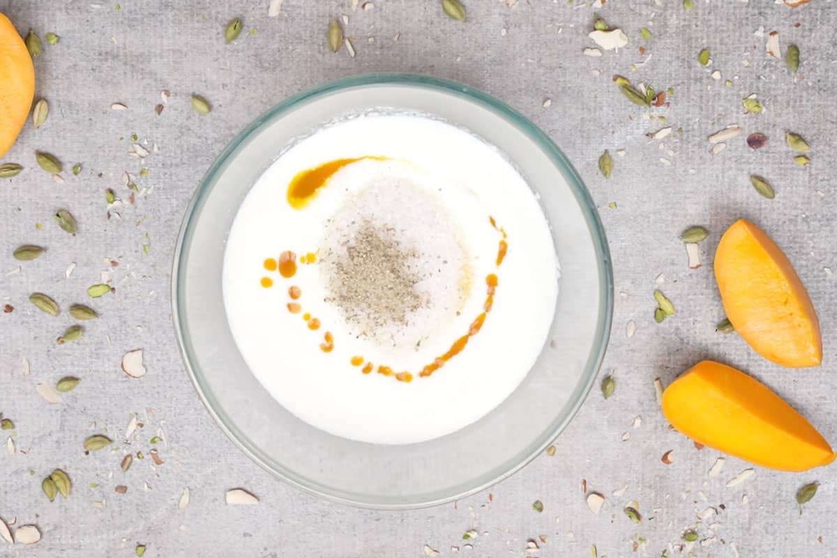 Mango puree, sugara nd cardamom powder added to the bowl.