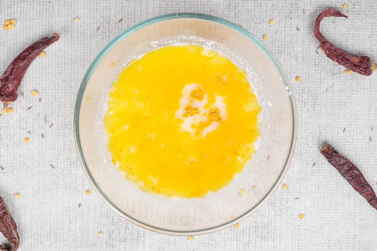 Water, turmeric powder and salt added to a bowl.