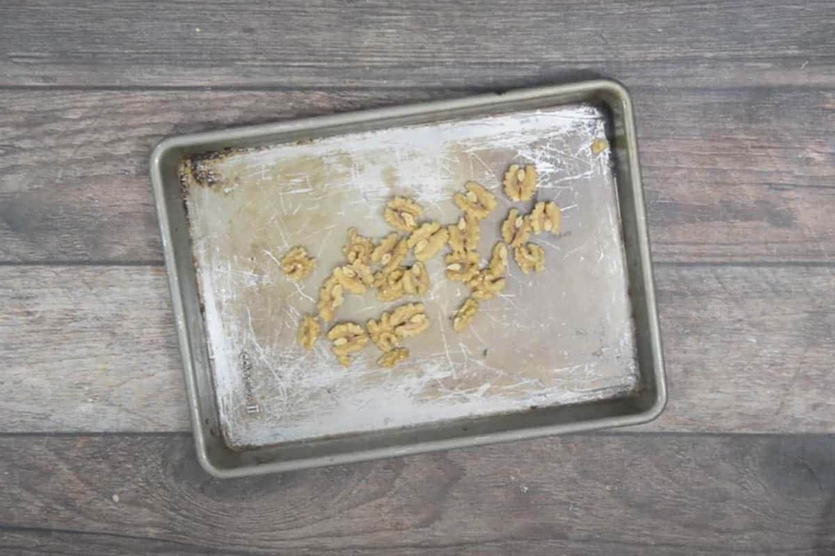 Walnuts spread on a baking tray.