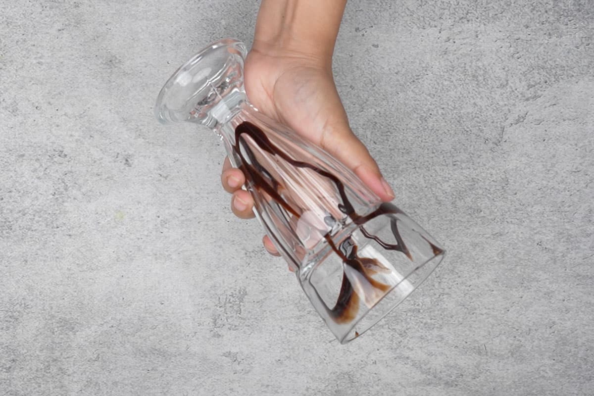 Serving glass drizzled with chocolate syrup.