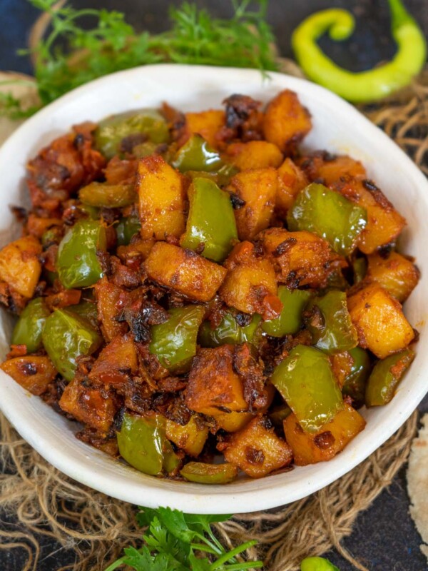 Dry Aloo Capsicum (Aloo Shimla Mirch) is an Indian stir fry made using potatoes and green bell peppers. Serve it for lunch or dinner with dal and roti or pack for lunch boxes with paratha.