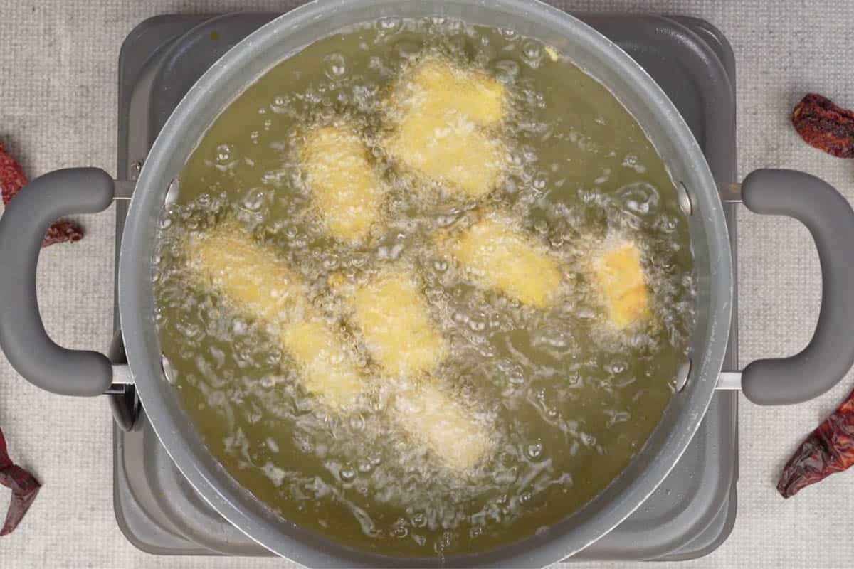 Paneer pakora frying in hot oil.