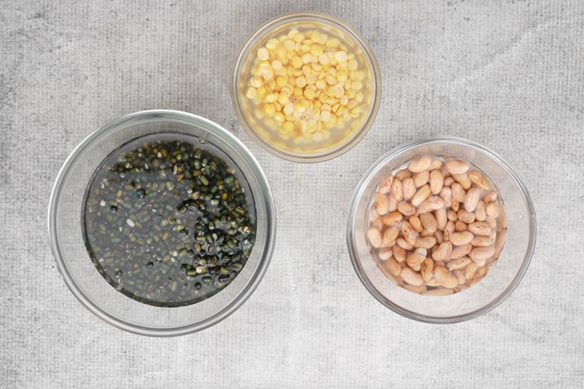Soaked whole urad, chana dal, and rajma in different bowls.