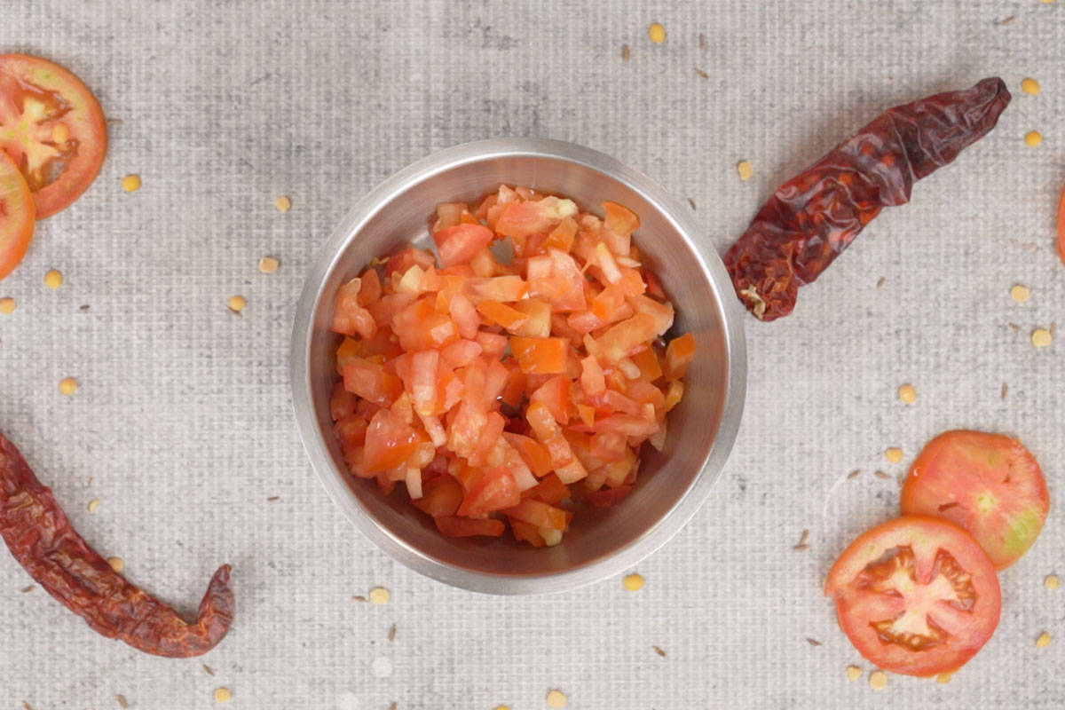 Chopped tomatoes added to a blender.