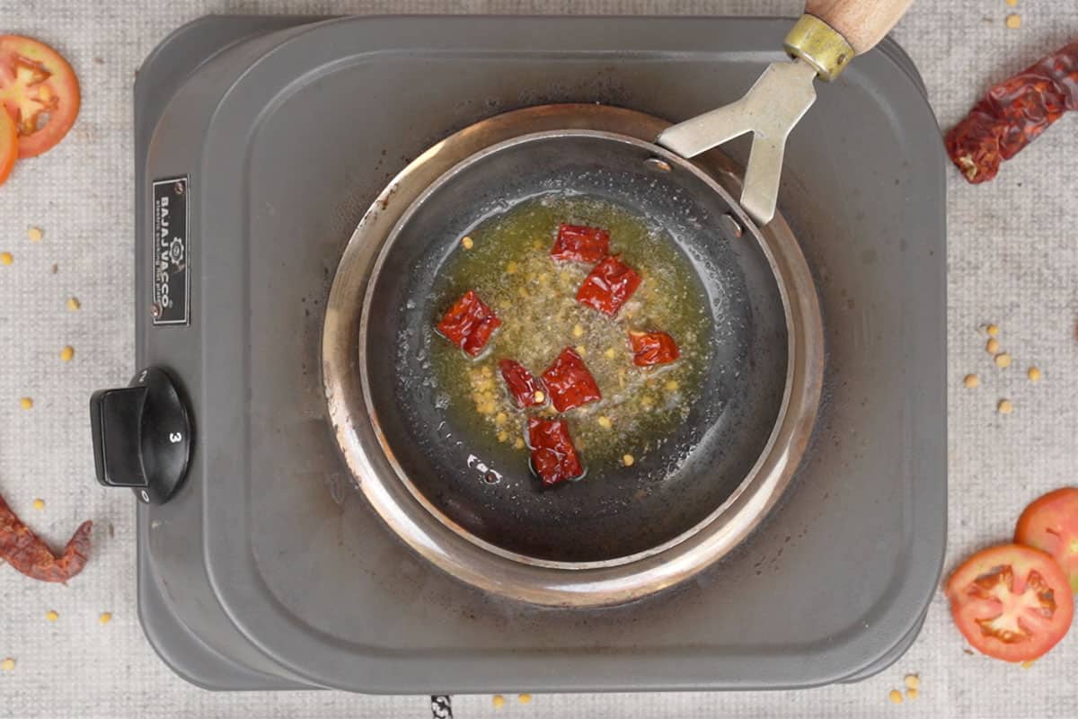 Mustard seeds, asafetida and dry red chili added to hot ghee.