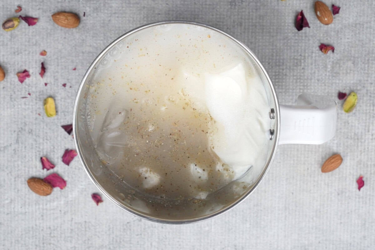 Lassi ingredients added to a blender.