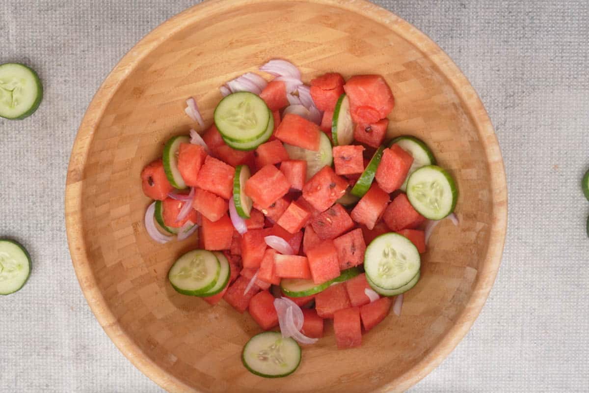 Watermelon, cucumber and onions mixed in a bowl.