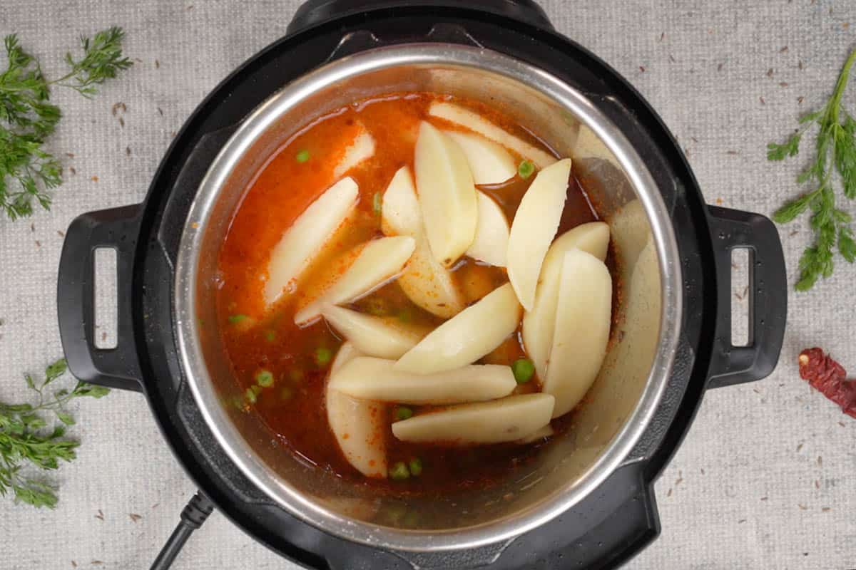 Green peas, potatoes, salt and water added to the pot.