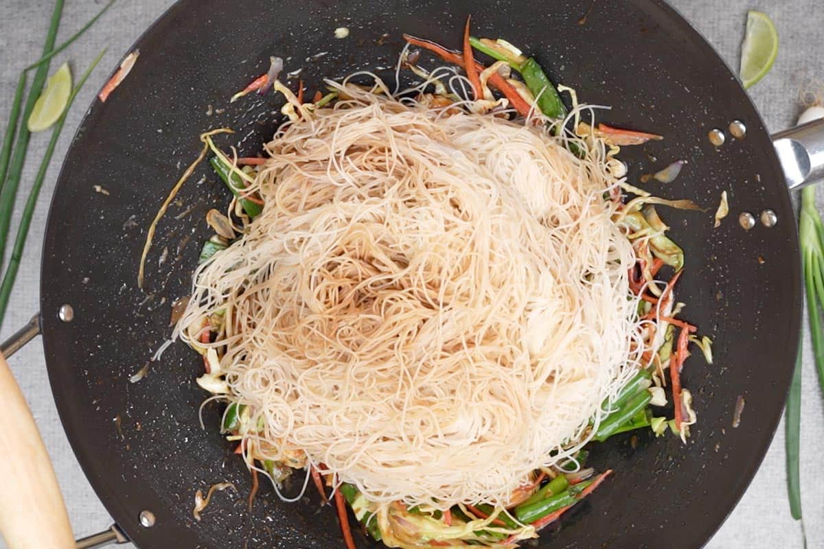 Rice noodles added to the wok.