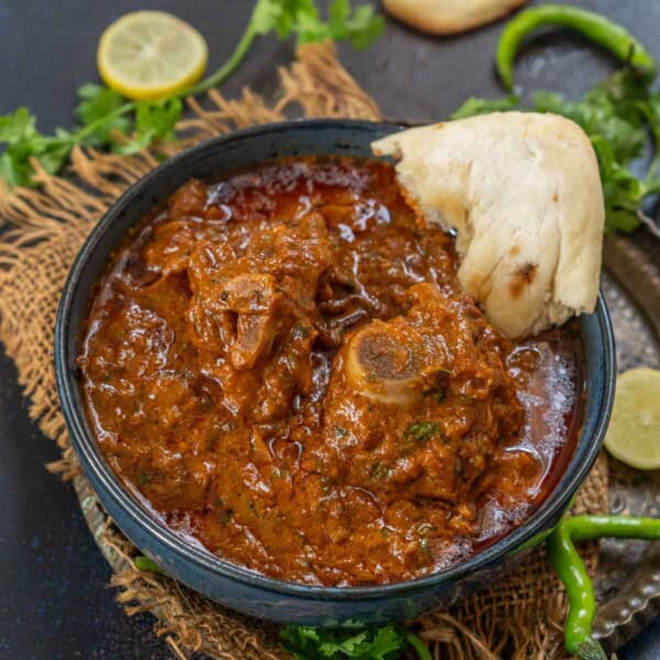 Bhuna Gosht (Mutton Bhuna) is a delicious goat meat curry popular in North India and Pakistan. Serve it with naan or khamiri roti for an unforgettable meal.