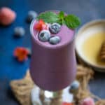 Triple berry oat tropical smoothie served in a glass.