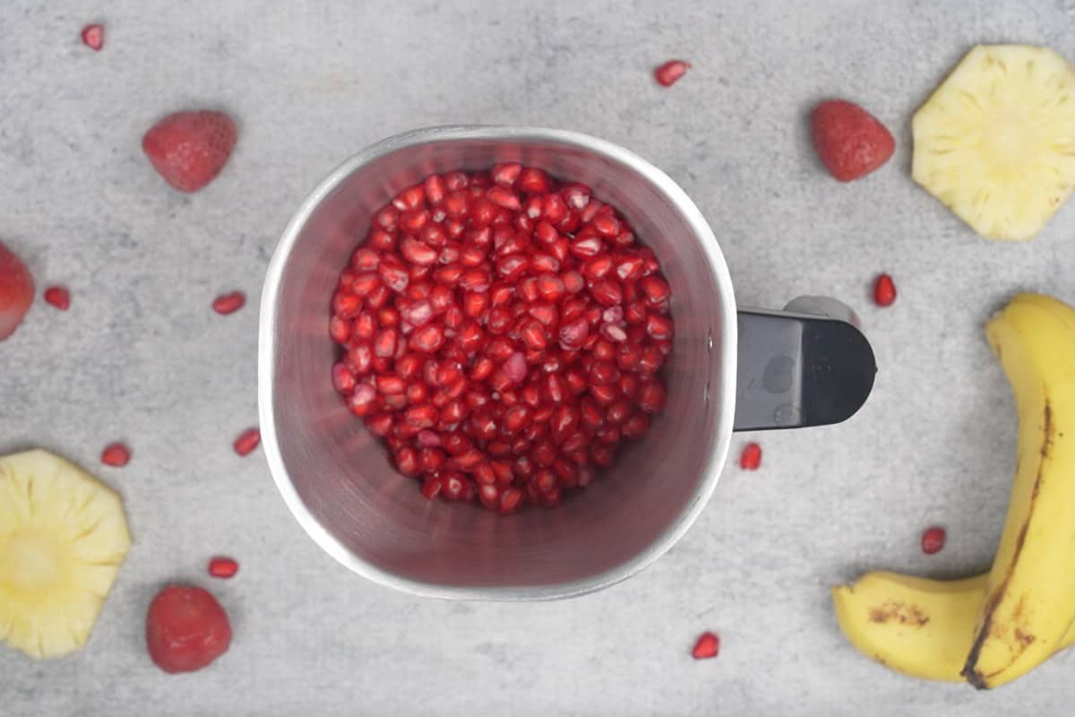 Pomegranate arils added to a blender.