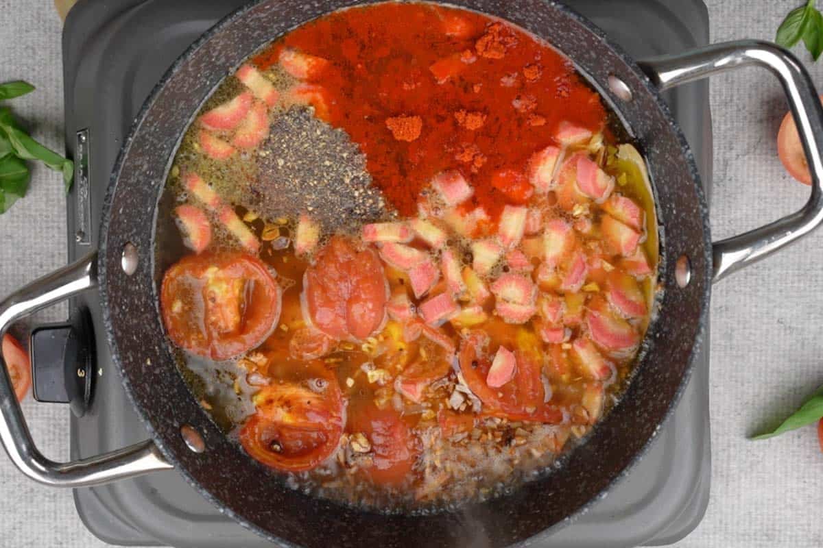 Roasted tomatoes, carrot, vegetable stock, salt, black pepper and cayenne pepper added to the pan.