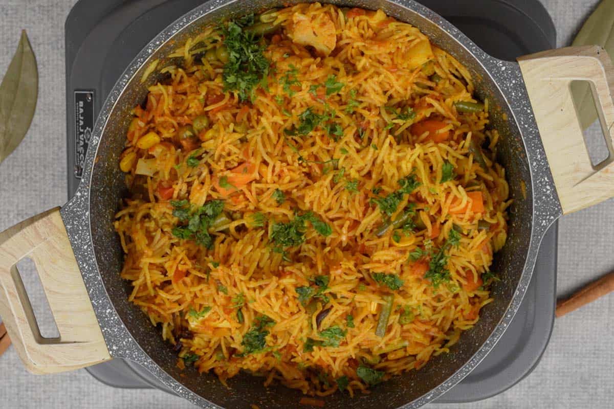 Ready masala rice fluffed with a fork.