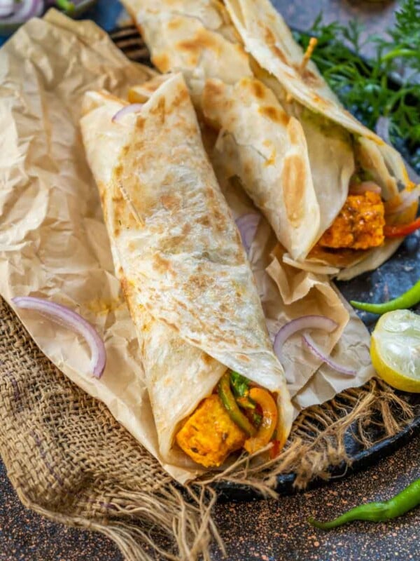 Paneer Kathi Roll is a popular Indian street food where lachha parathas are slathered with green chutney and filled with a spicy paneer bell pepper filling. Serve them for a filling meal any time of the day (vegetarian).
