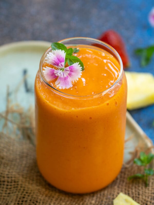 Make this Tropical smoothie cafe copycat Sunrise Sunset Tropical Smoothie using frozen fruits, orange juice, and coconut water. This creamy and nutritious beverage is a great way to start your day (vegan, gluten-free).