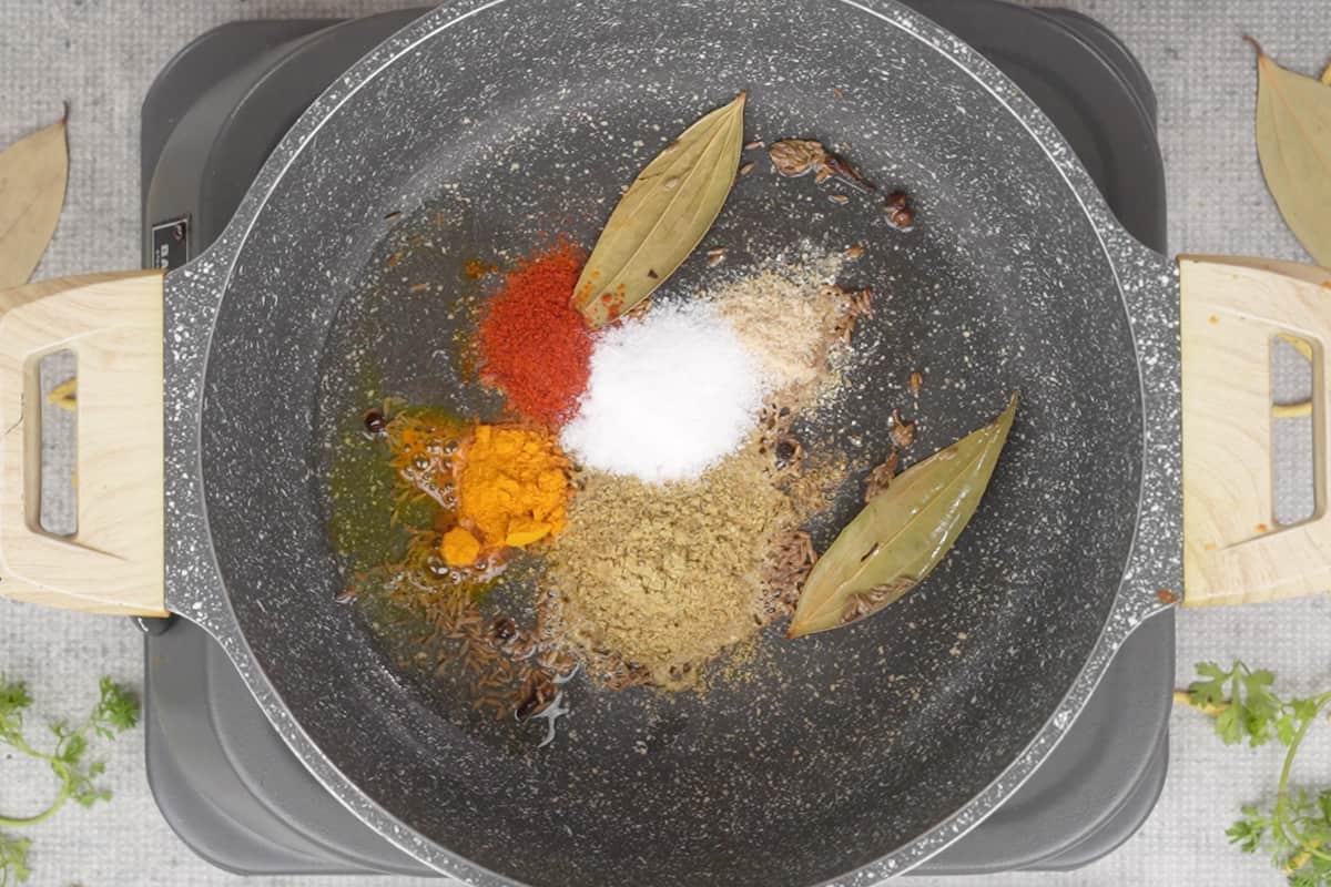 Spice powders added to the pan.