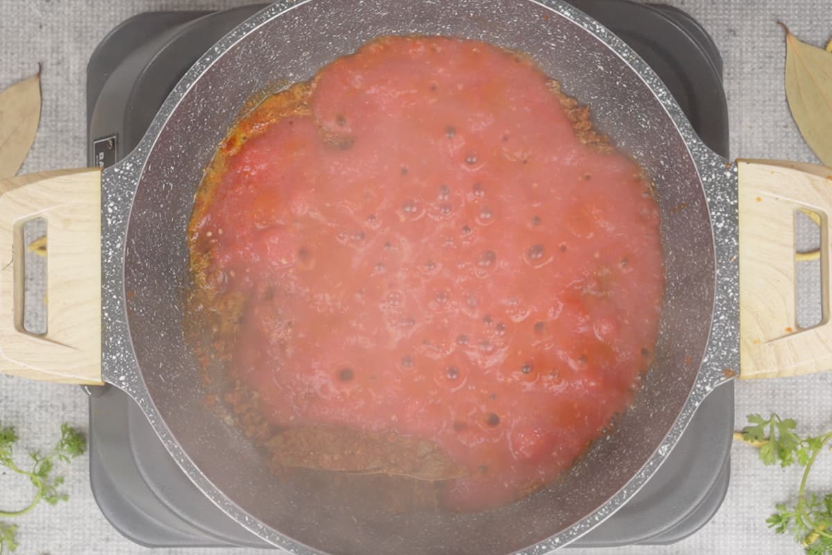 Pureed tomatoes added to the pan.