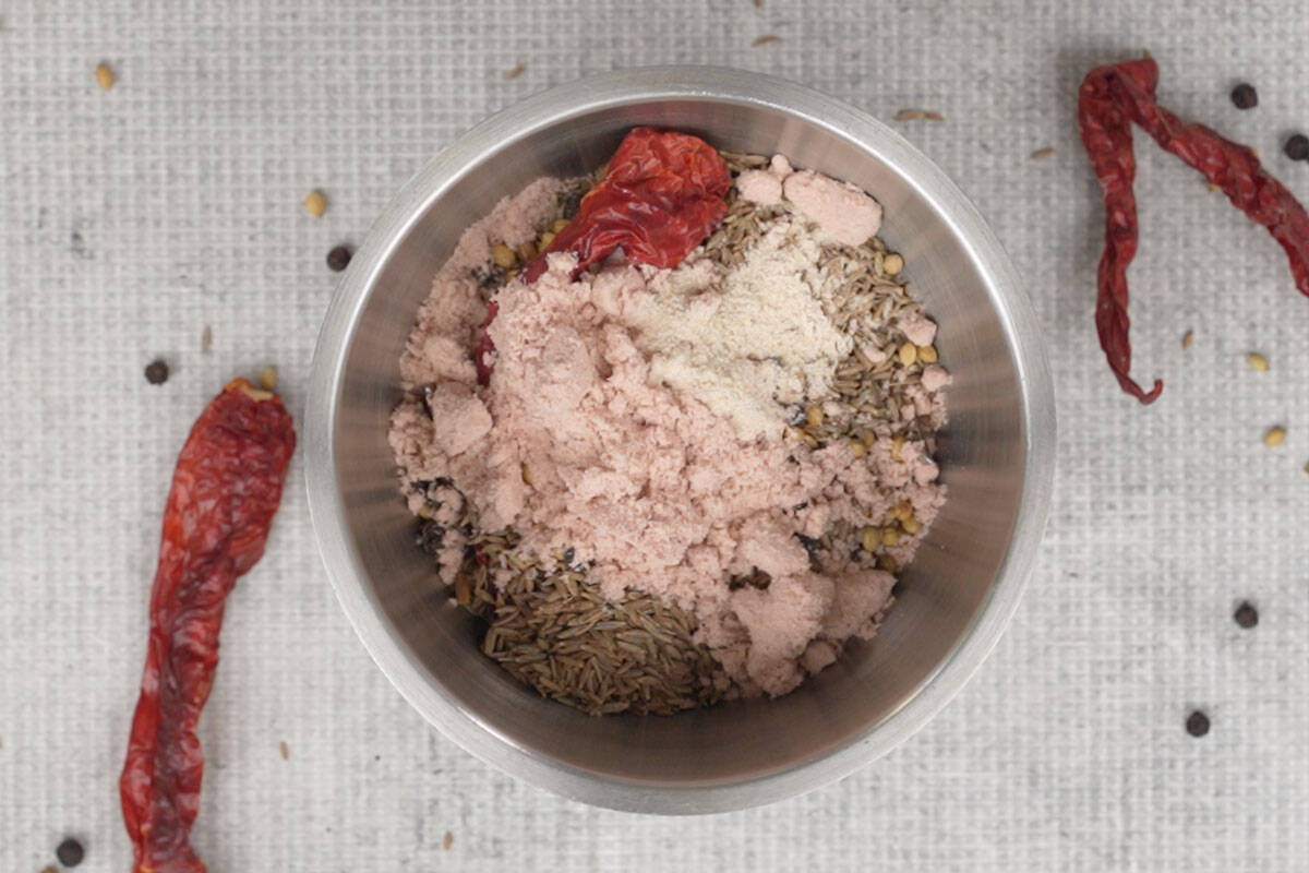 Roasted ingredients, black salt and asafetida added to a grinder.