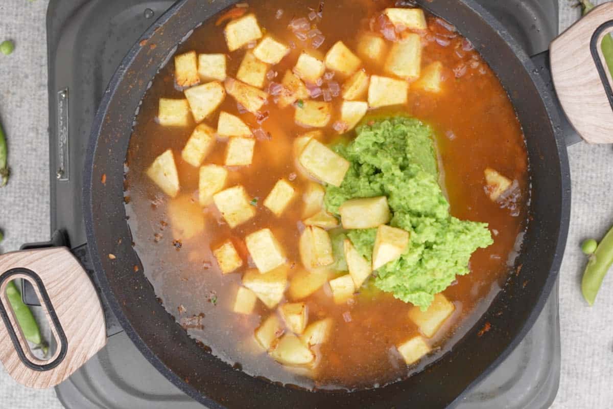 Peas paste, salt, fried potatoes and water added to the pan.