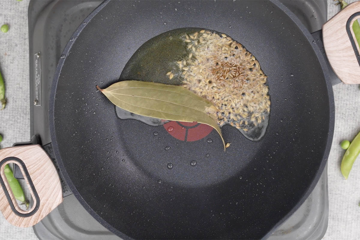 Cumin seeds and bay leaves added to hot ghee.