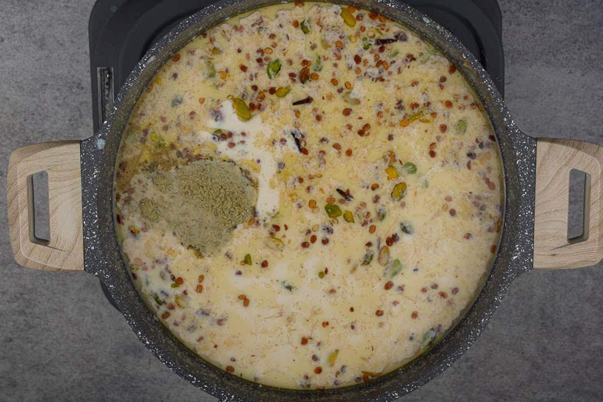 Sugar, saffron soaked in milk and cardamom powder added to the pan.