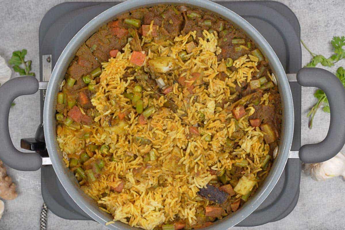 Ready green pulao fluffed with a fork.