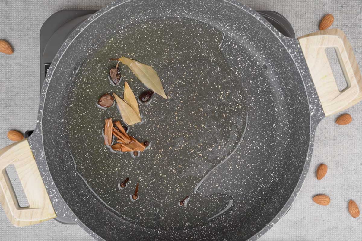 Whole spices added to hot ghee in the pan.