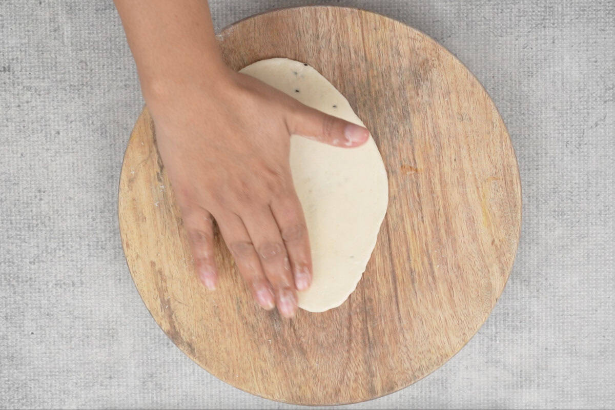 Applying water on the plain side of the naan.