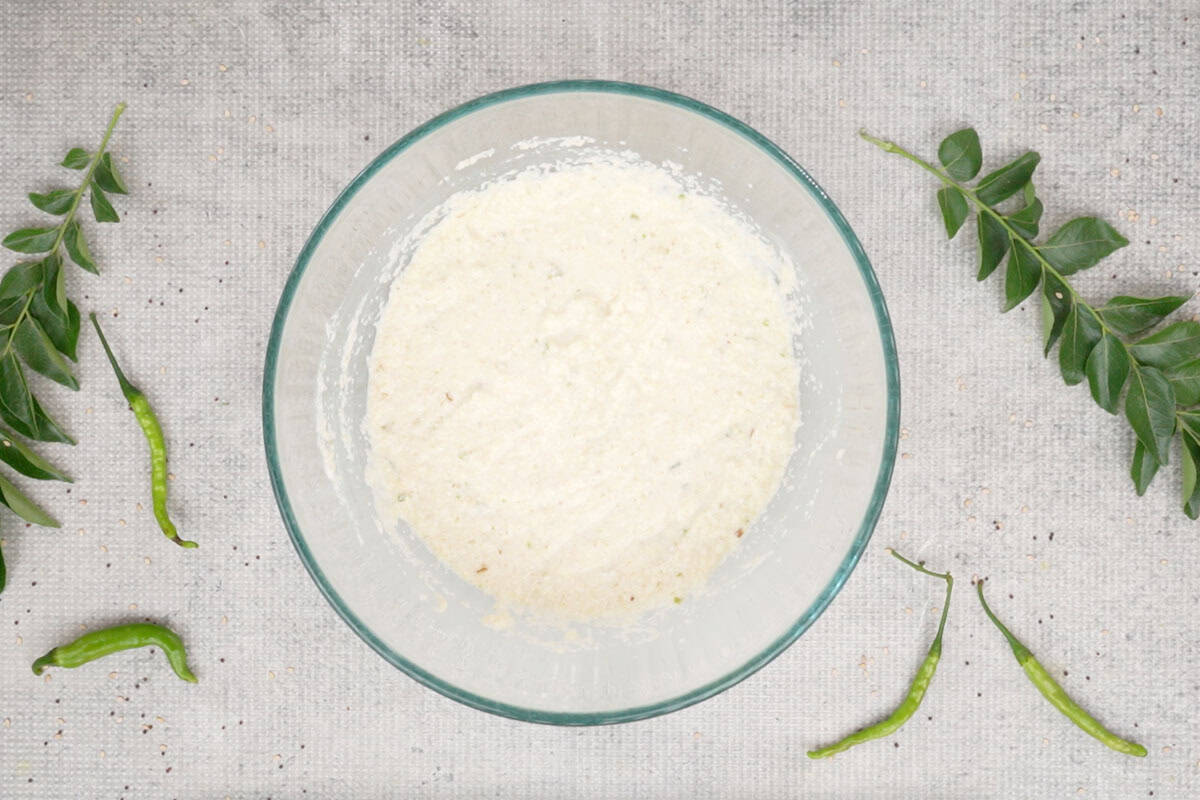 Rava dhokla ingredients added to a bowl and mixed to form a batter.