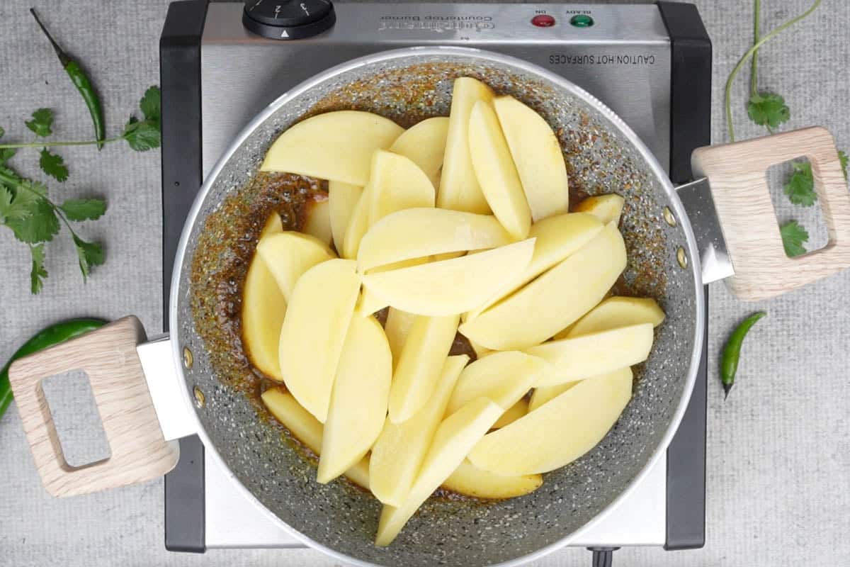 Potato wedges added to the pan.