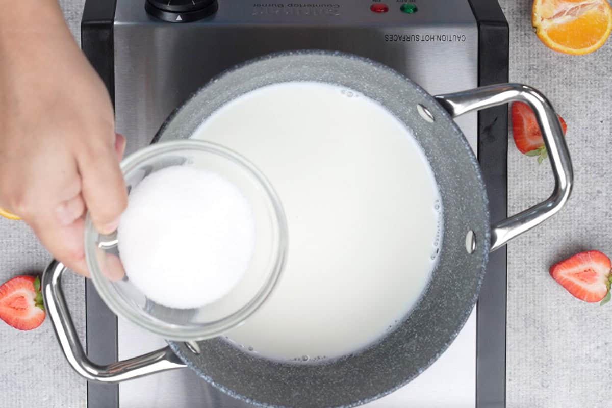 Adding sugar to the pan.