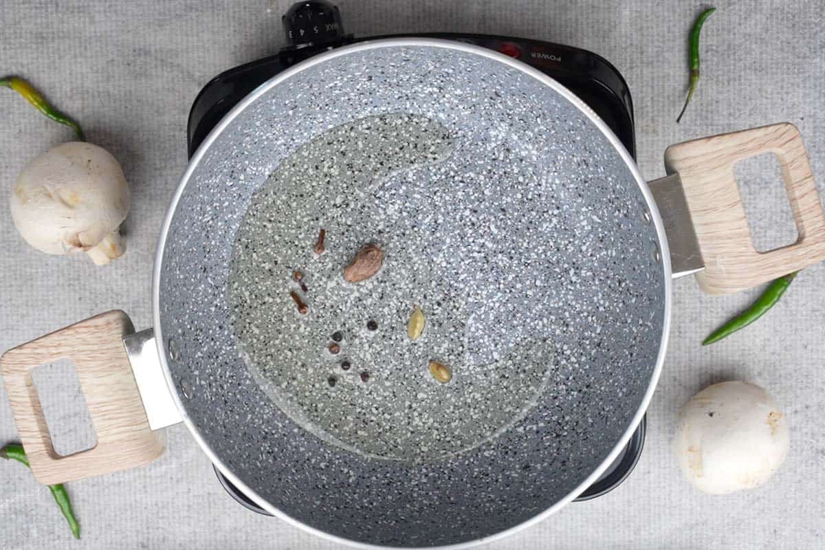 Whole spices added to the pan.