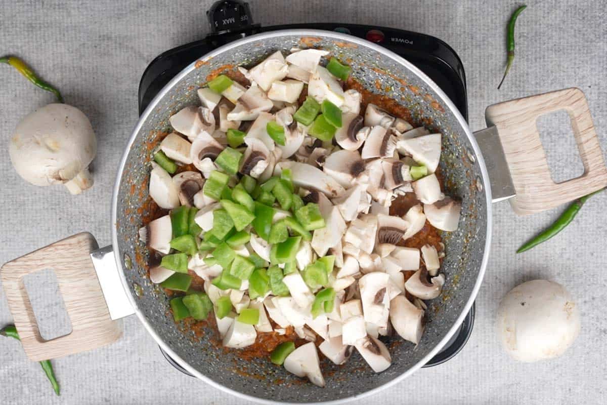 Mushrooms and bell pepper added to the pan.