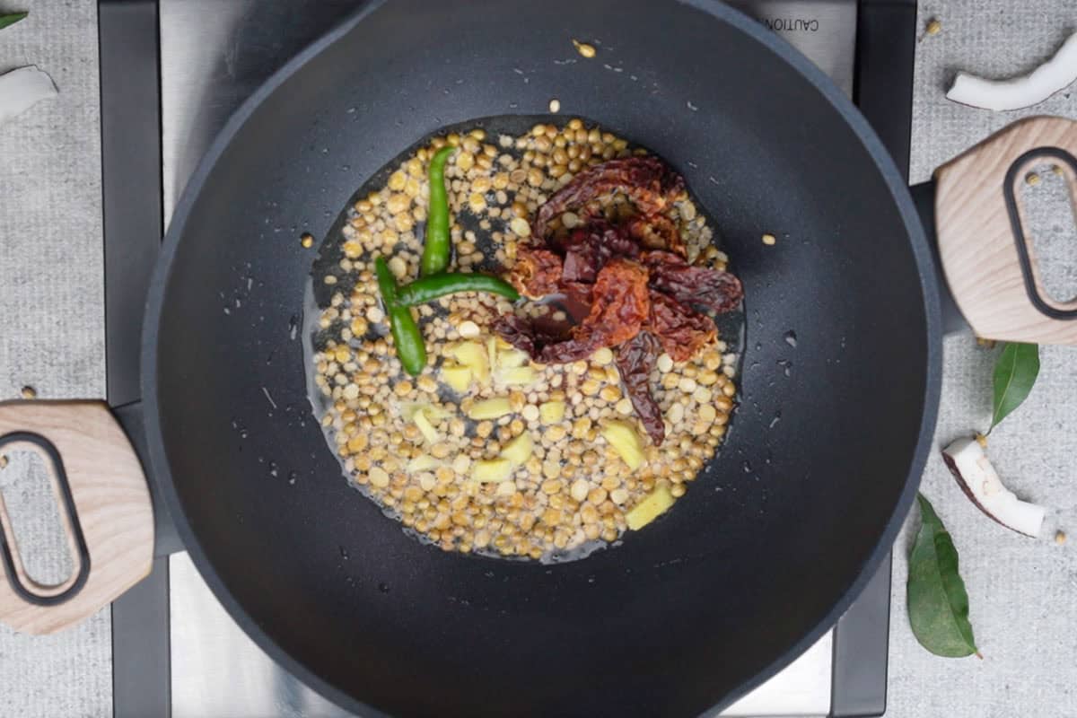 Dried red chilies, green chilies and ginger added to the pan.