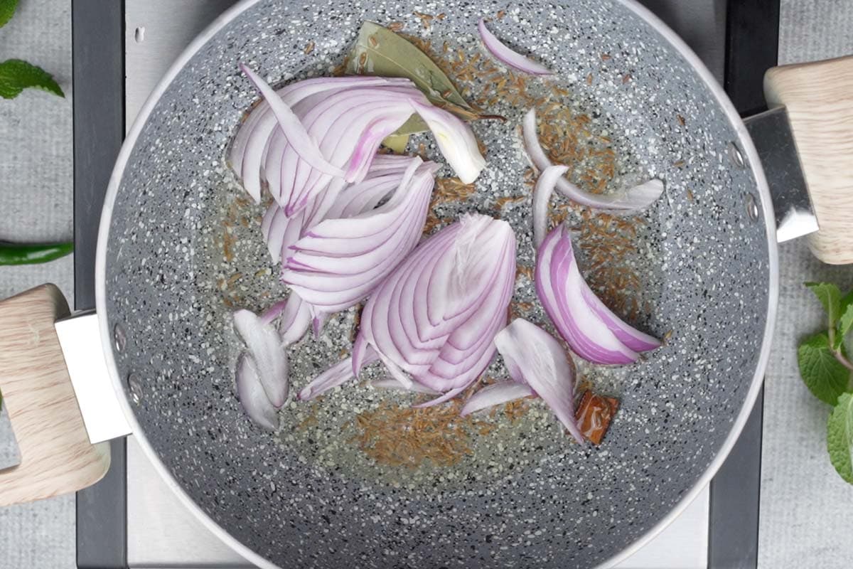 Sliced onions added to the pan.
