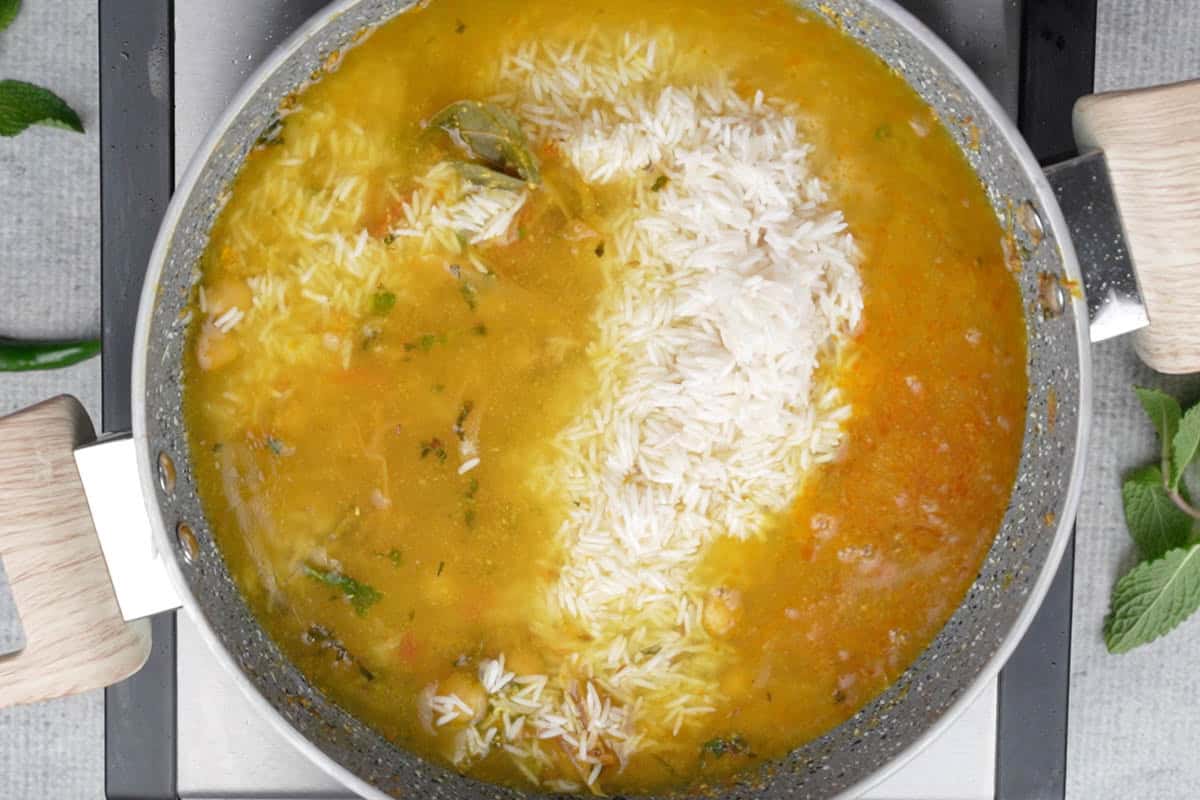 Soaked rice and water added to the pan.