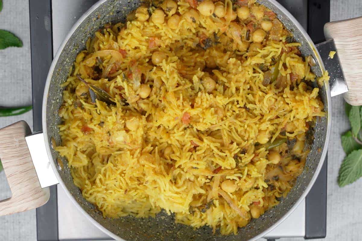 Ready chana pulao fluffed with a fork.