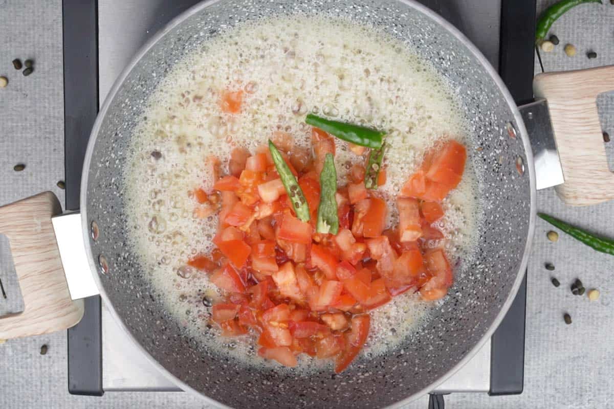 Tomatoes and green chilies added to the pan.