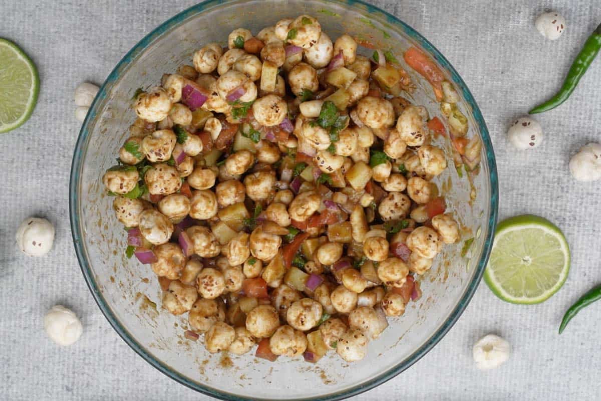 Roasted makhana mixed with the ingredients in the bowl.