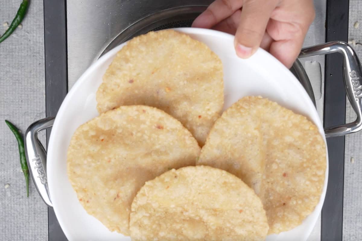 4-5 half fried puri on a plate.