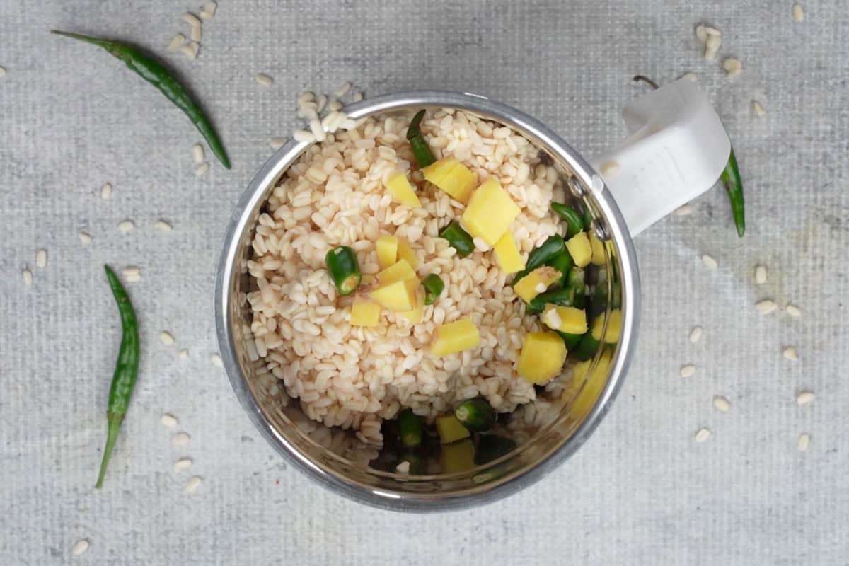 Urad dal added to a blender with ginger, green chilies and water.