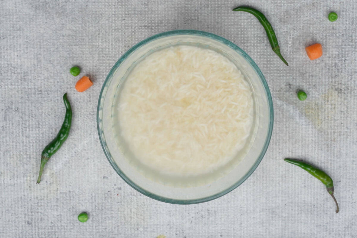 Rice soaked in water in a bowl.