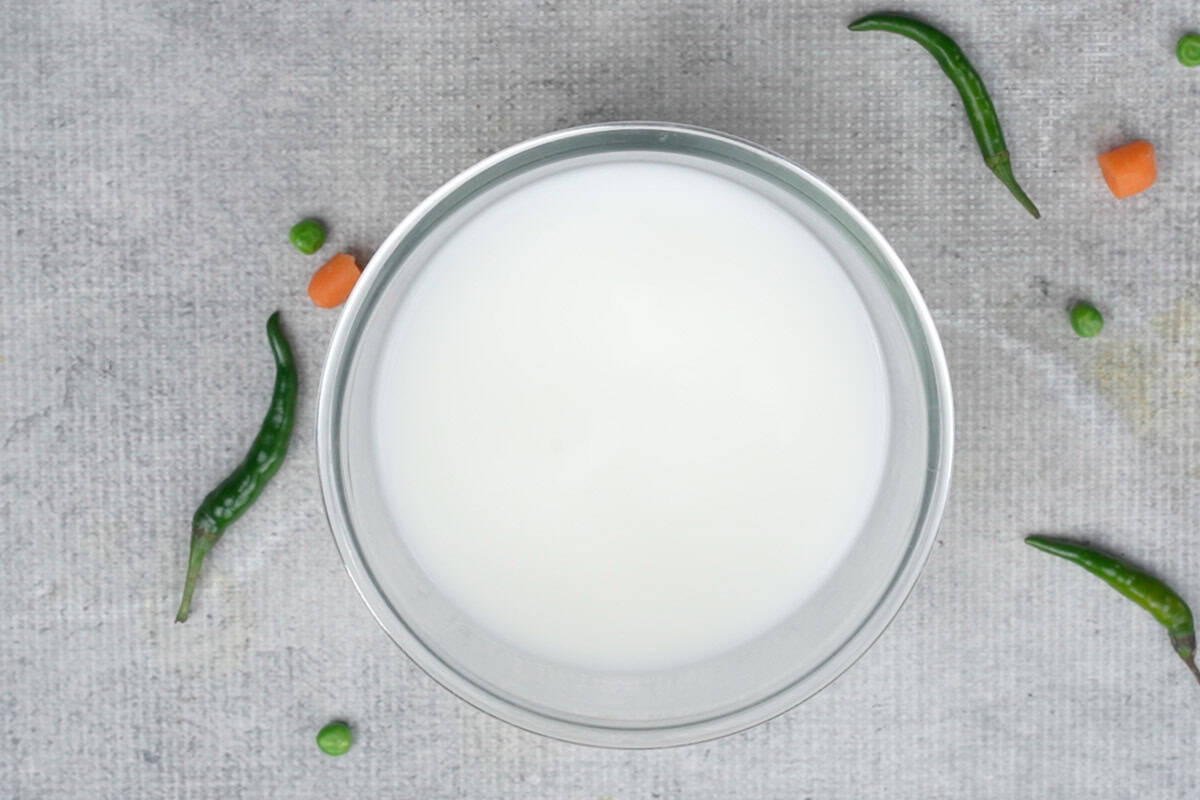 Yogurt mixed with water in a bowl to make chaas.