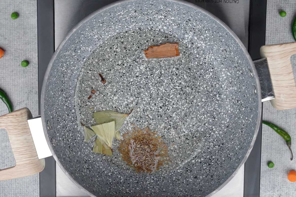 Whole spiced added to hot oil in a pan.