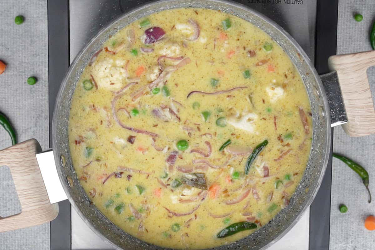 Vegetables, spice powders and chaas added to the pan.