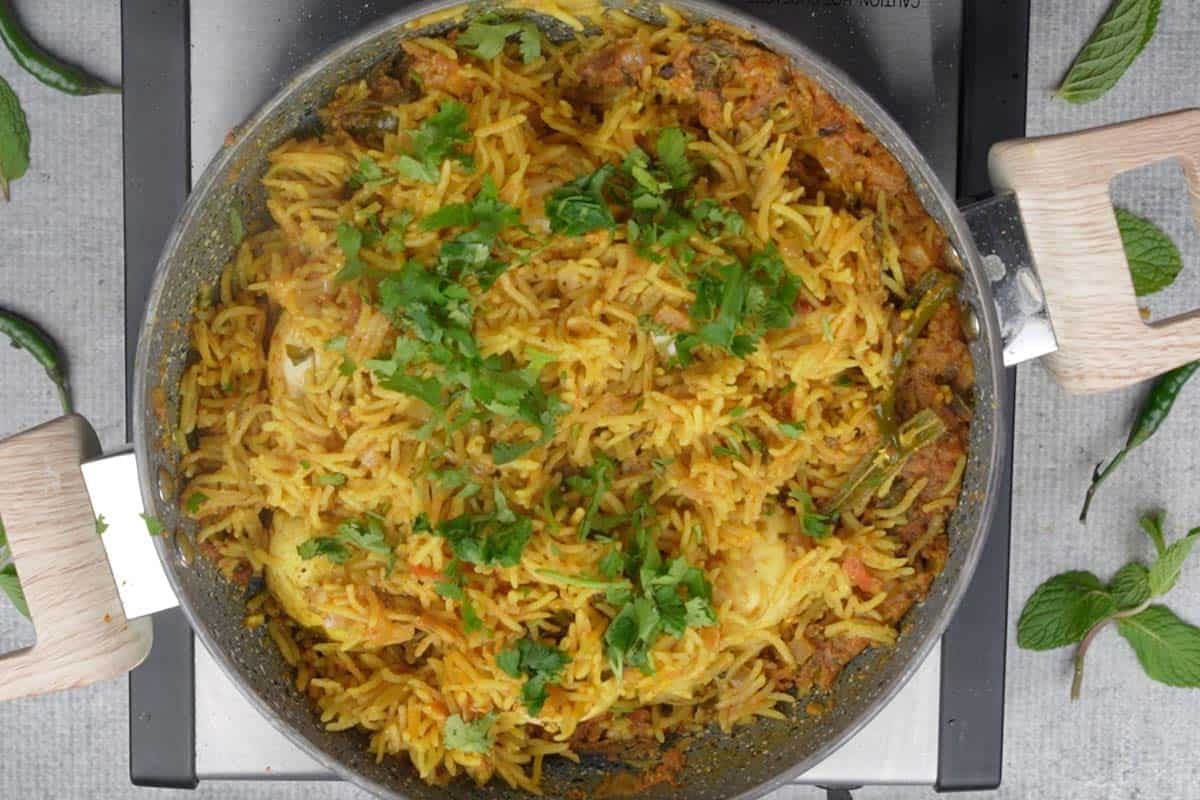 Ready egg pulao garnished with chopped cilantro.
