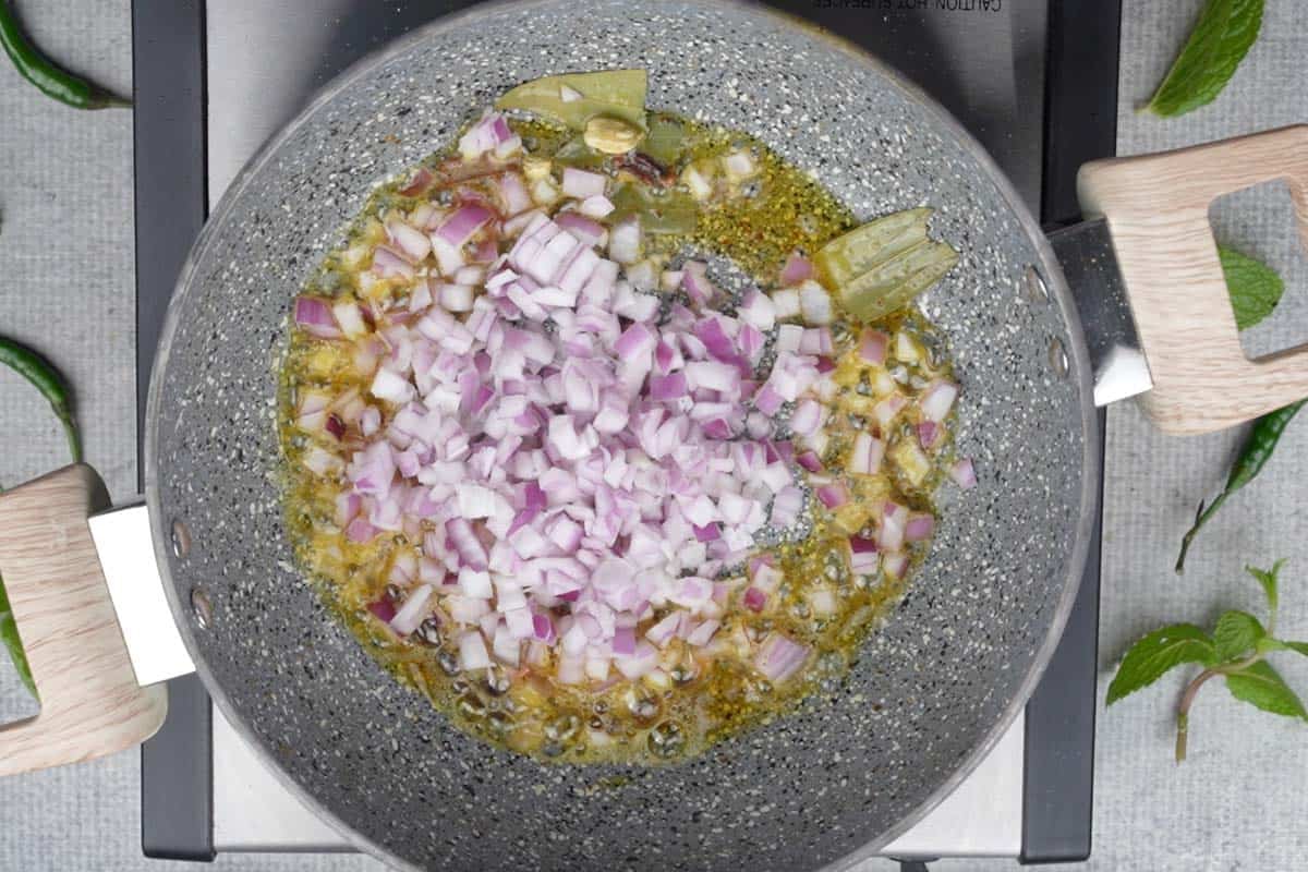 Chopped onions added to the pan.