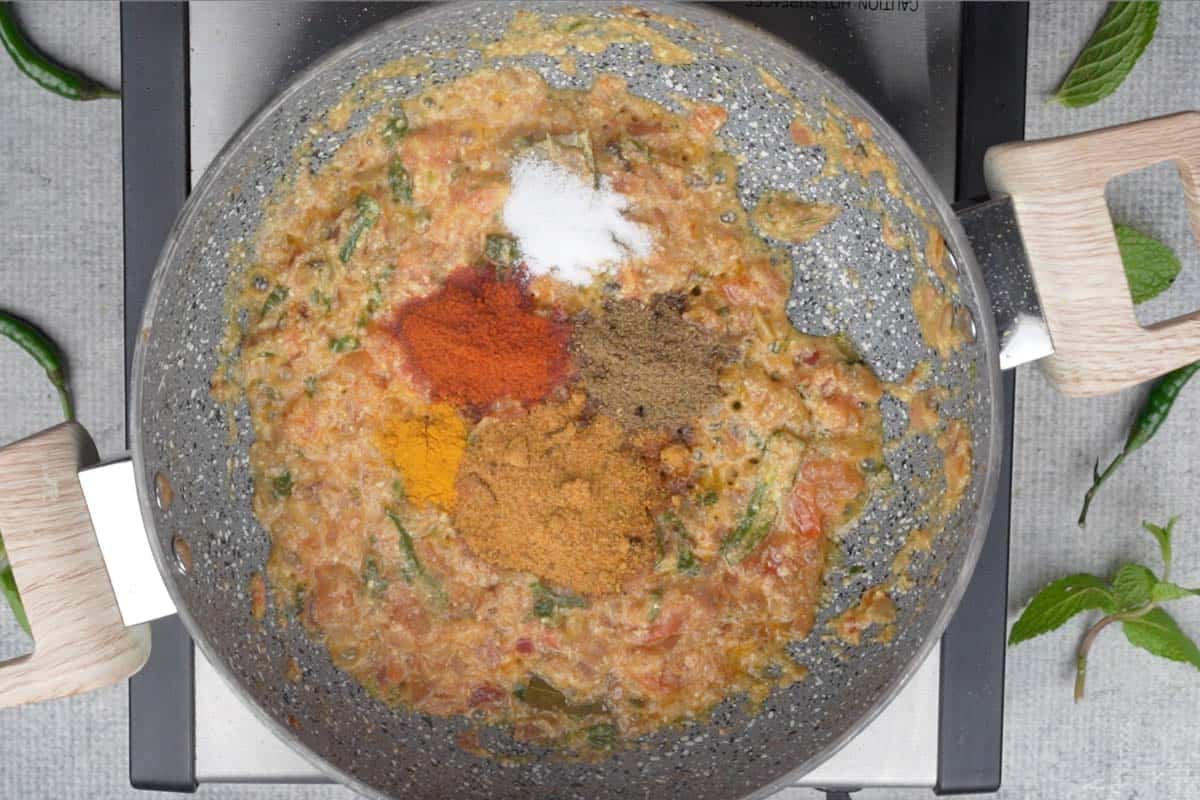 Spice powders added to the pan.