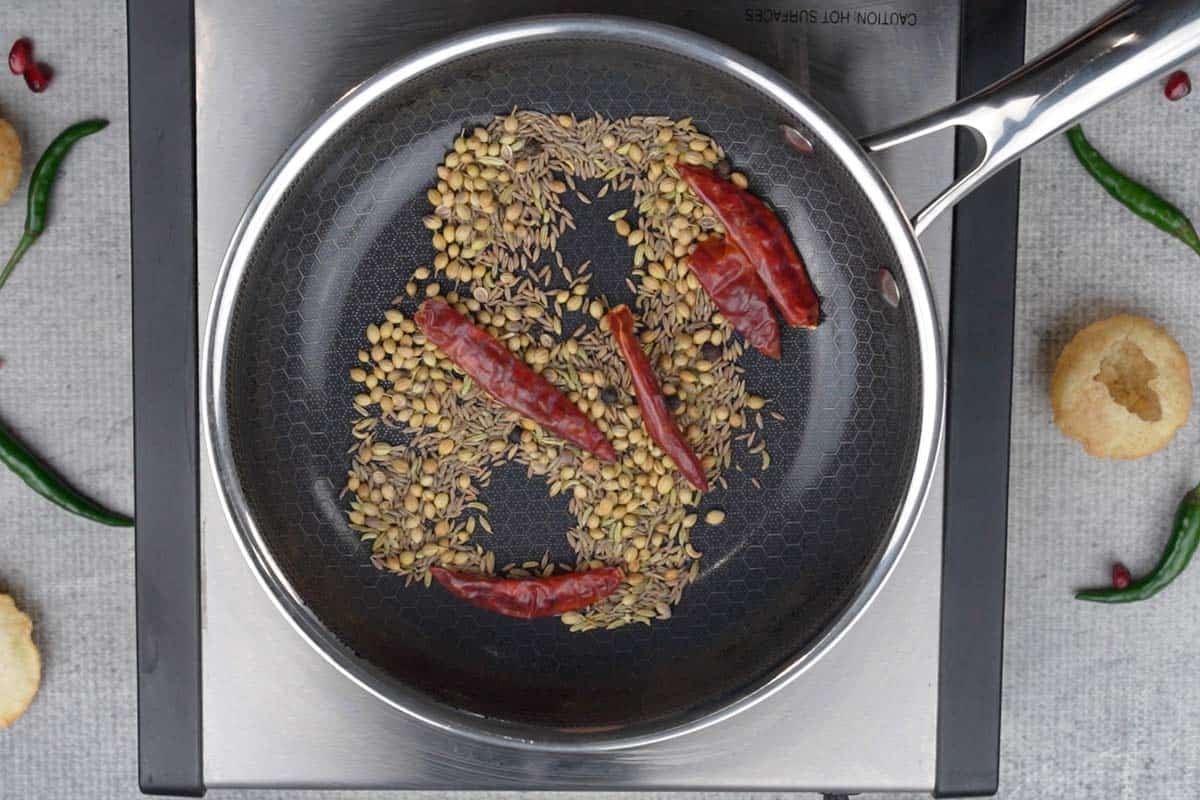 Bhaja masala spices roasting in a pan.